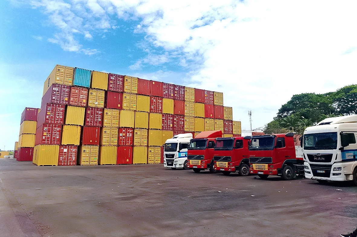Camioes alinhados junto aos contentores no porto
